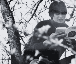 Barbara-Mira Jakob sitzt auf dem Nussbaum und liest